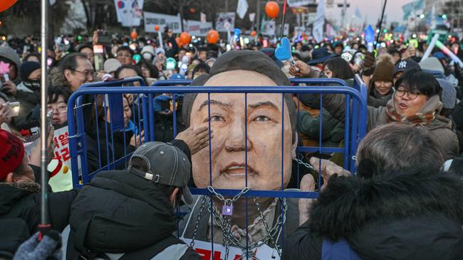 Protesters calling for the ouster of South Korea President Yoon Suk Yeol hit an effigy of him as they gather for the outcome of the second martial law impeachment vote outside the National Assembly in Seoul. Picture: AFP