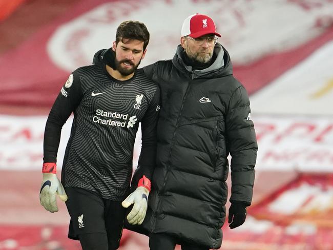 Liverpool's German manager Jurgen Klopp (R) reacts with Liverpool's Brazilian goalkeeper Alisson Becker (L) at the end of the English Premier League football match between Liverpool and Burnley at Anfield in Liverpool, north west England on January 21, 2021. (Photo by Jon Super / POOL / AFP) / RESTRICTED TO EDITORIAL USE. No use with unauthorized audio, video, data, fixture lists, club/league logos or 'live' services. Online in-match use limited to 120 images. An additional 40 images may be used in extra time. No video emulation. Social media in-match use limited to 120 images. An additional 40 images may be used in extra time. No use in betting publications, games or single club/league/player publications. /