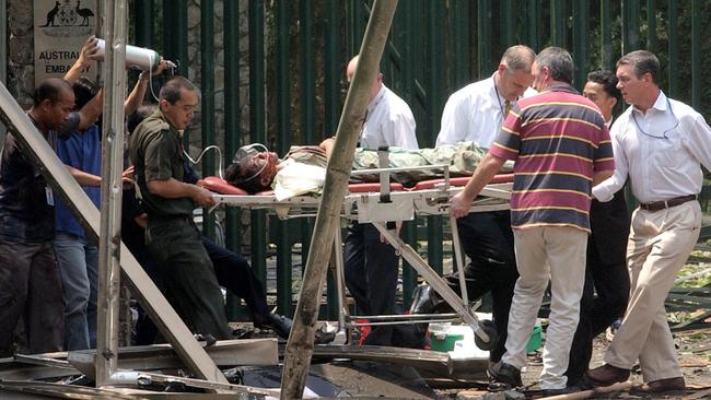 An injured person is carried out of the Australian embassy in Jakarta on a stretcher, following the car bomb blast in 2004. Picture: AP