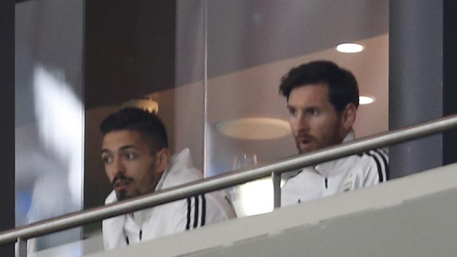 Lionel Messi, right, watches the international friendly soccer match between Spain and Argentina