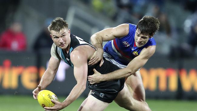 Port Adelaide’s Ollie Wines is tackled by Western Bulldogs’ Josh Dunkley at Adelaide Oval. Picture SARAH REED