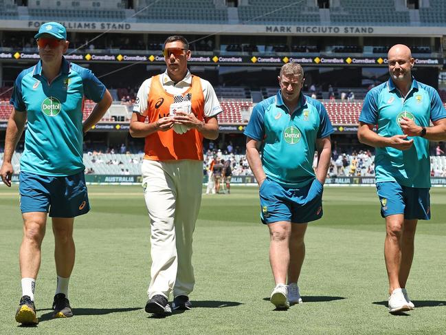 ADELAIDE, AUSTRALIA - JANUARY 18: Andrew McDonald, head coach of Australia, Scott Boland, Scott Burns and Matthew Nicks of the Adelaide Crows Football Club walk from the field at the tea break during day two of the First Test in the Mens Test match series between Australia and West Indies at Adelaide Oval on January 18, 2024 in Adelaide, Australia. (Photo by Paul Kane/Getty Images)