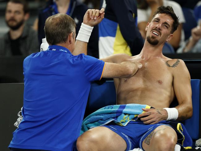 Thanasi Kokkinakis is treated for injury during his round two loss. Picture:Daniel Pockett/Getty Images