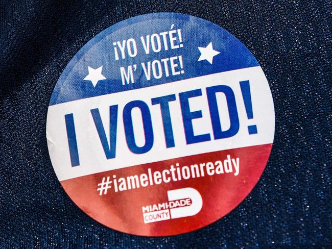 (FILES) In this file photo a man wears a sticker which says 'I Voted" during the Florida primary election at Miami Beach City Hall in Miami, on March 17, 2020. - An online voting system approved in three US states is vulnerable to manipulation by hackers and may not protect ballot secrecy, according to an analysis by security researchers. Scientists from the Massachusetts Institute of Technology and University of Michigan said in a research paper released June 7, 2020 that Democracy Live's OmniBallot platform represents "a severe risk to election security and could allow attackers to alter election results without detection." (Photo by CHANDAN KHANNA / AFP)