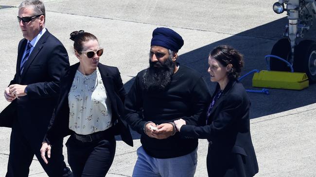 Queensland Police officers and detectives escort Rajwinder Singh from a chartered jet to a waiting police car at Cairns Airport after being extradited from New Delhi to Cairns via Melbourne on March 2. Picture: Brendan Radke