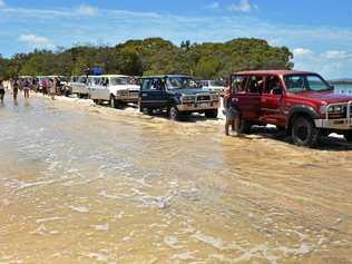 A 2.2m high tide at Inskip Point gives four-wheel-drives some beach challenges lining up for the Fraser Island barge. Picture: Greg Miller