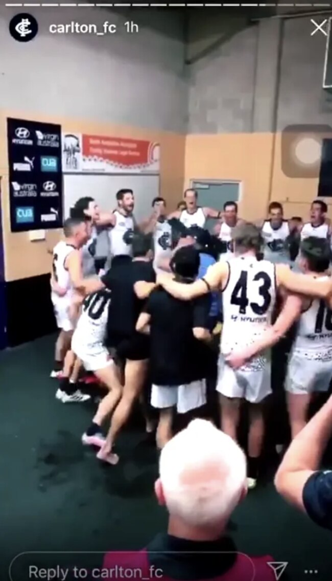 Michael Gibbons touches a cameraman during Carlton's team song.