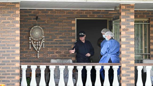 Police officers on the balcony of a home at Inglis St at Grange, in Brisbane’s inner north. Picture: Lyndon Mechielsen/Courier Mail