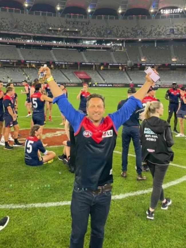 Burbank on the ground at Optus Stadium after the Demons’ grand final win.