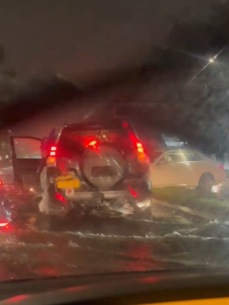 Taren Point Rd was inundated with water, with one couple filming their attempt to navigate the dangerous traffic. Picture: Supplied