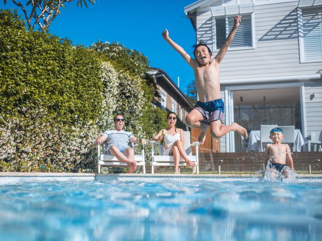 Family having fun in the backyard. Kids are swimming.