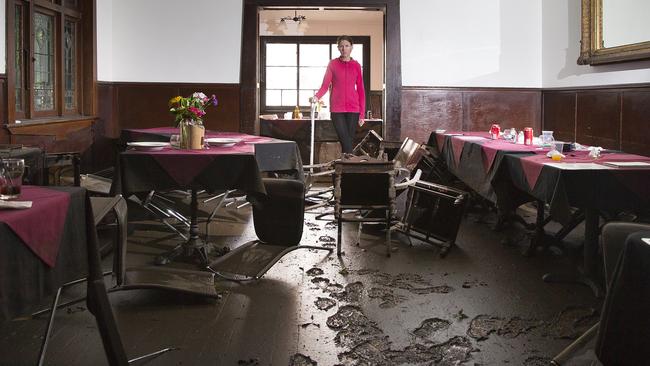 Pete Cohen, the manager of the pub, tries to clean the devastated restaurant area. Picture: Melvyne Knipe