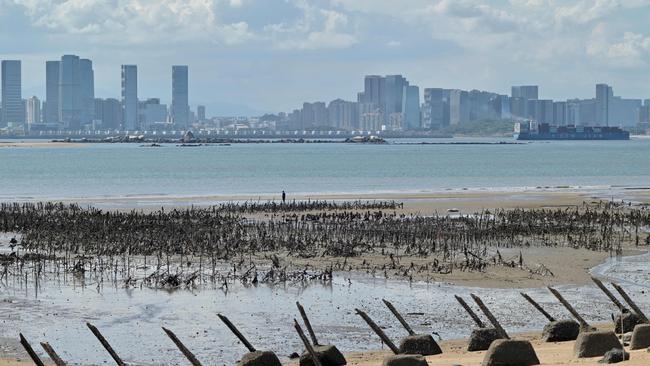 The Xiamen city skyline on the Chinese mainland is seen past anti-landing spikes placed along the coast of Lieyu islet on Taiwan's Kinmen islands. Picture: AFP