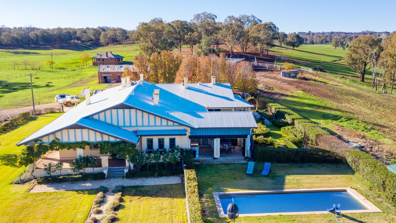 The house is set in a garden with an inground pool.