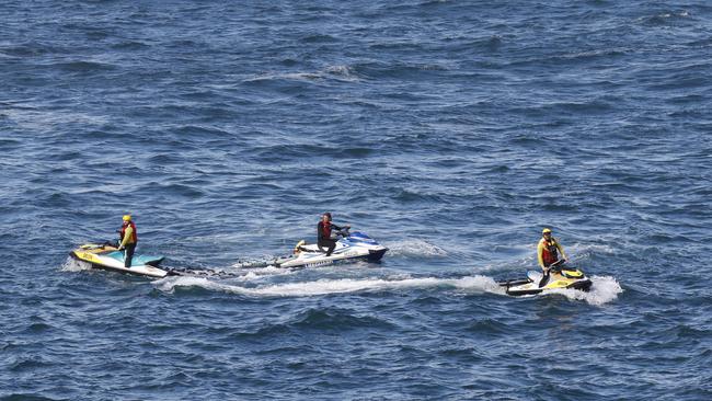 Pictured at Storm Bay in Kiama are Surf Rescue searching an area where two men were washed from rocks while rock fishing late yesterday. Picture: Richard Dobson