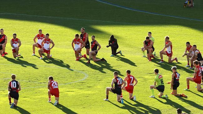 Players from both teams take a knee for Black Lives Matter during the Round two AFL match between the Sydney and Essendon at the SCG. Picture: Phil Hillyard