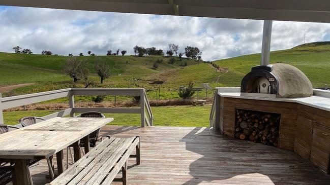 The Shed’s idyllic outdoor area with a wood fire oven and bench.