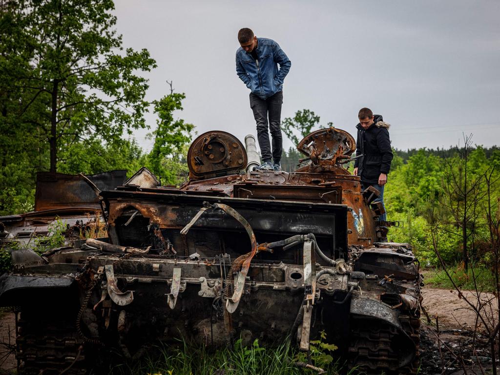 Locals examine a destroyed Russian tank outside Kyiv on Tuesday. Photo: Dimitar DILKOFF / AFP