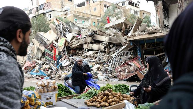 Residents buy vegetables from an ambulant vendor stationed amid the destruction in the neighbourhood of Shiyah in Beirut's southern suburbs on November 28, a day after a ceasefire between Israel and Hezbollah took effect. Picture: AFP