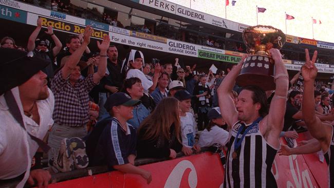 Brian Leys holding the 1998 premiership trophy cup aloft after that year’s grand final win.