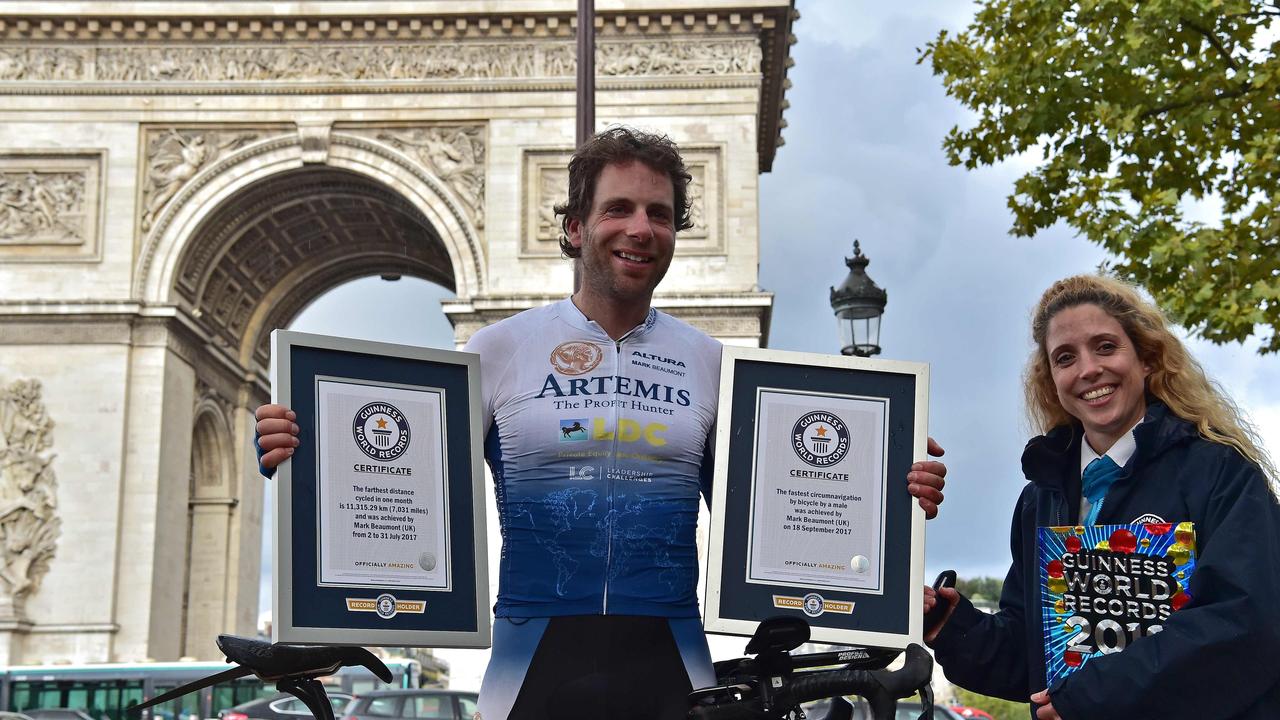 Cyclist Mark Beaumont poses for pictures with Guinness World Records certificates after arriving at the Arc de Triomphe in Paris on September 18, 2017 to complete his tour around the world. Picture: AFP