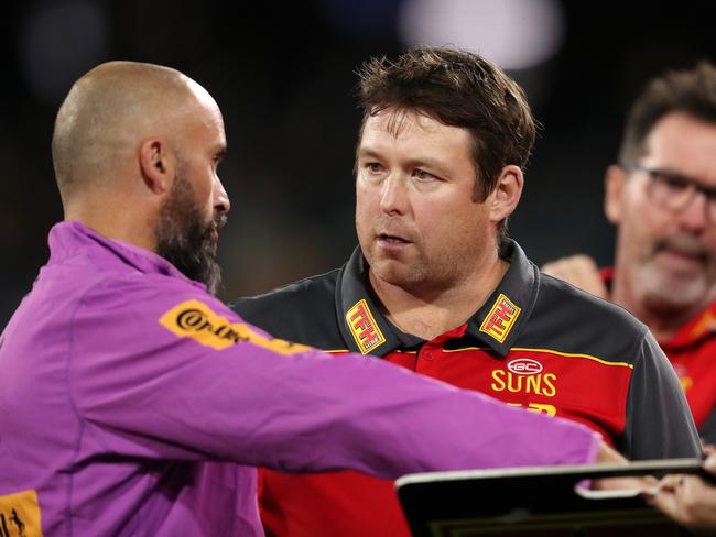 Stuart Dew chatting to Rhys Shaw during an AFL game. Picture: Sarah Reed/Getty Images)