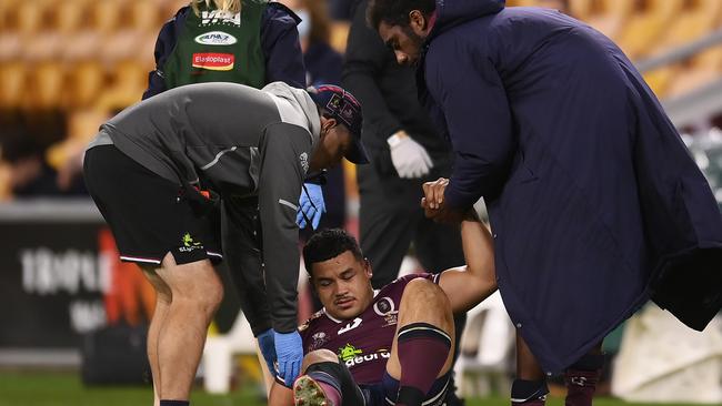 Hunter Paisami requires assistance after hurting his knee in the Reds’ win over the Rebels. Picture: Albert Perez/Getty Images