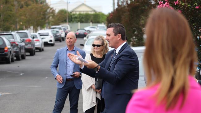 Auctioneer Jarrod Leonard stood between buyers advocates Tony Slack, left, and Cate Bakos at the Walker St auction. Picture: Peter Farago