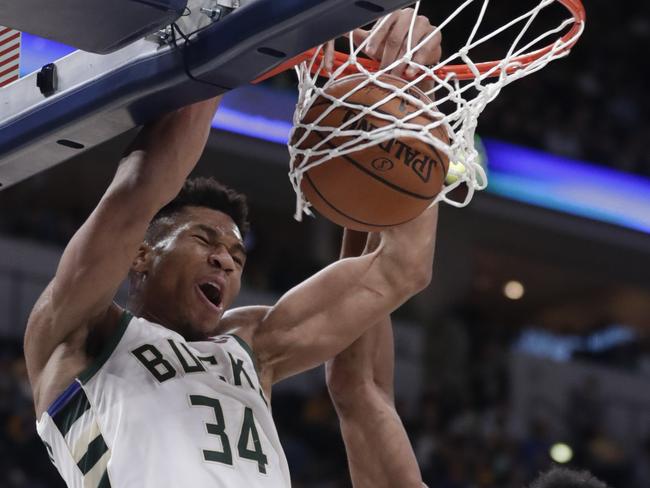 Bucks superstar Giannis Antetokounmpo dunks over Pacers forward Thaddeus Young.