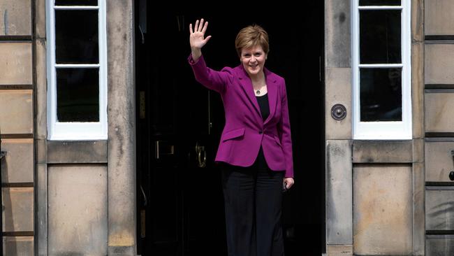 Ms Sturgeon waves from the steps of her official residence Bute House in Edinburgh.