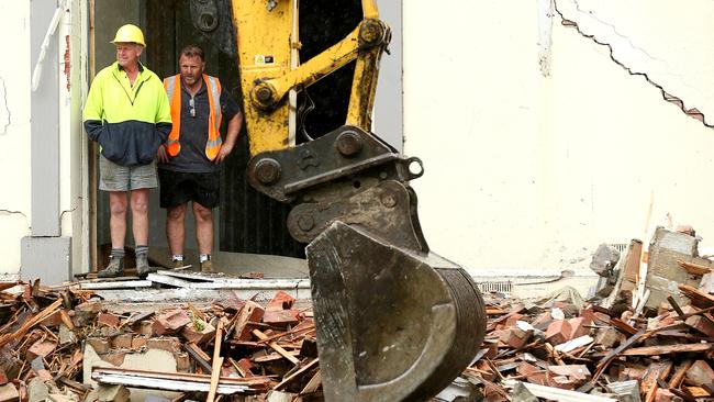 A bulldozer demolishes part of the house. Picture: Mark Stewart