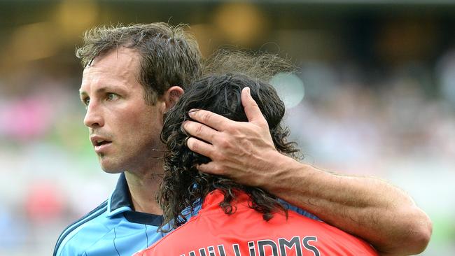 Lucas Neill playing for Sydney FC hugs it out with Melbourne Heart’s David Williams.