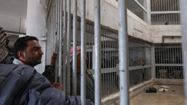 People stand inside the Saydnaya prison as Syrian rescuers search for potential hidden basements at the facility in Damascus. Picture: AFP.