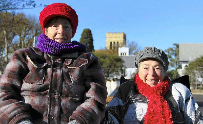 Marlene Pickard and Thelma Keogh set up chairs in the sun at yesterday’s markets to keep warm. Picture: Erin Smith