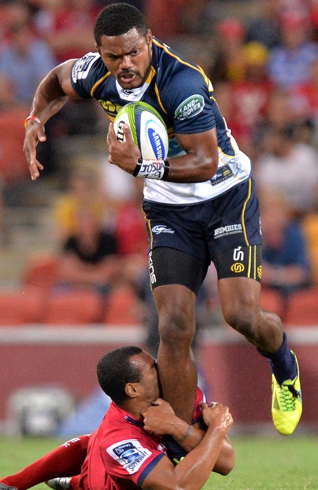 Henry Speight of the Brumbies attempts to break away from the defence of Will Genia of the Reds.