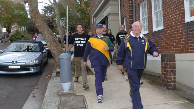 Former Prime Minister John Howard cut a very normal figure, particularly when followed by Greenpeace protesters, as during this morning walk in 2004. Photo: John/Grainger