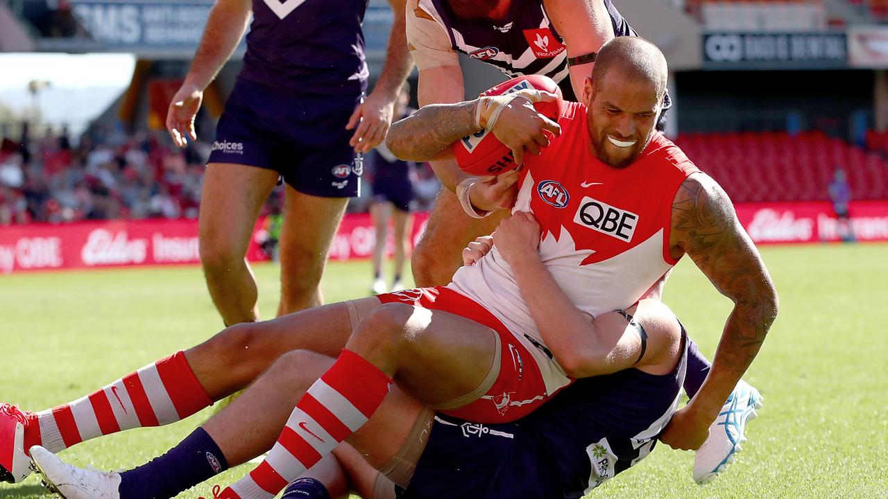 GOLD COAST, AUSTRALIA - JULY 25: Lance Franklin of the Swans is tackled during the round 19 AFL match between Sydney Swans and Fremantle Dockers at Metricon Stadium on July 25, 2021 in Gold Coast, Australia. (Photo by Kelly Defina/Getty Images)