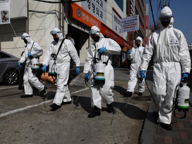 SEOUL, SOUTH KOREA - MARCH 06: South Korean soldiers wearing protective gear, spray antiseptic solution against the coronavirus (COVID-19) in Gangnam district on March 06, 2020 in Seoul, South Korea. The South Korean government has raised the coronavirus alert to the "highest level" as confirmed case numbers continue to rise across the country. According to the Korea Centers for Disease Control and Prevention, 518 new cases were reported on Monday, with the death toll rising to 43. The total number of infections in the nation is currently 6,284, the highest outside of China. (Photo by Chung Sung-Jun/Getty Images) *** BESTPIX ***