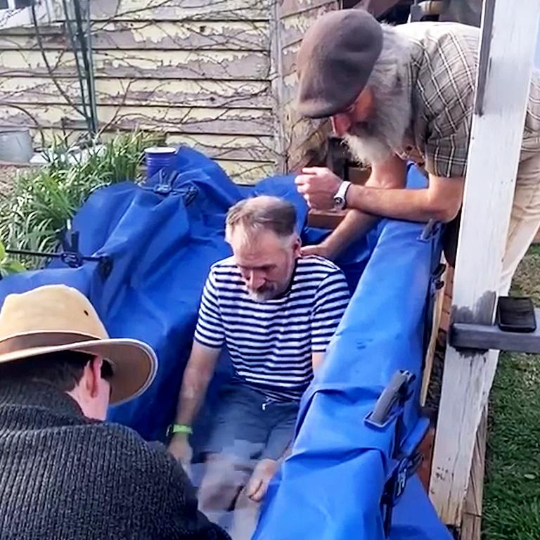 Jason Struhs being baptised in a backyard.