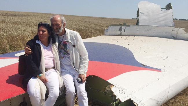 Jerzy Dyczynski and Angela Rudhart-Dyczynski sit on part of the wreckage of the crashed aircraft in Ukraine in 2014. Picture: AP