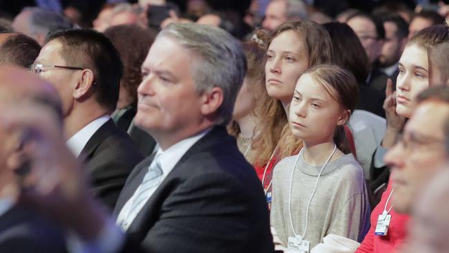 Mathias Cormann, centre, and Greta Thunberg, right, listen to Donald Trump’s opening address at Davos. Picture: AP