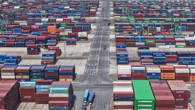 Trucks transport containers at a port in Shanghai. Picture: AFP
