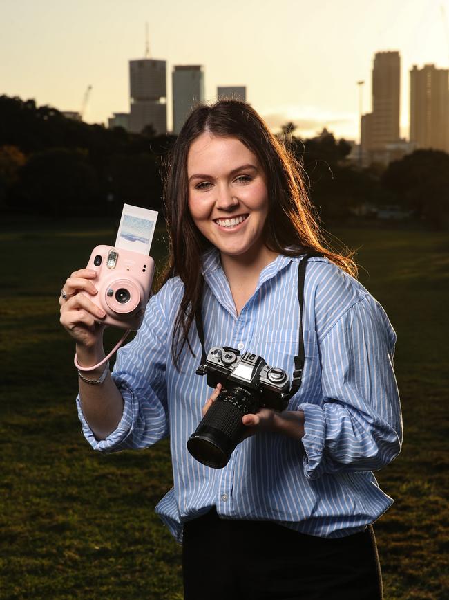 Photographer Lucy Brown, 23, with her polaroid and her grandfathers film camera as they are coming back on trend. Picture: Zak Simmonds