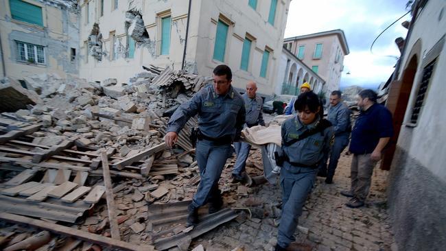 Rescuers carry a man from the rubble after a 6.2 magnitude earthquake struck central Italy. Picture: Filippo Monteforte.