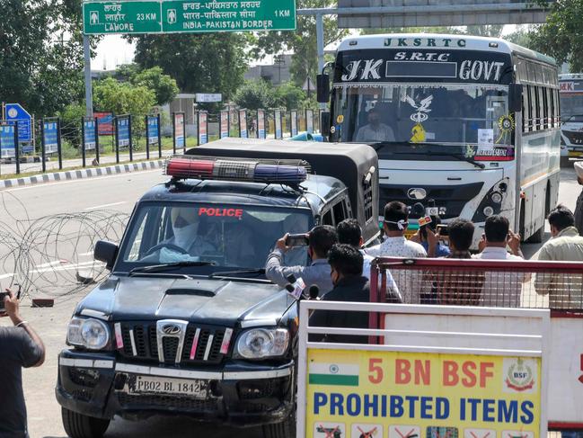 Punjab police vehicles escort buses transporting Indian nationals previously stranded in Pakistan to a quarantine facility. Picture: AFP.