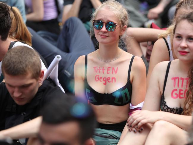 Young women have written "Tits against G20" on their chests during a protest in Hamburg. Picture: AFP PHOTO / Ronny HARTMANN