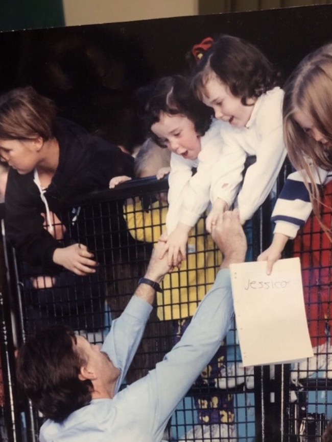 Robert Shaw reaches up to his twins Amy and Zoe after a Fitzroy win at the MCG.