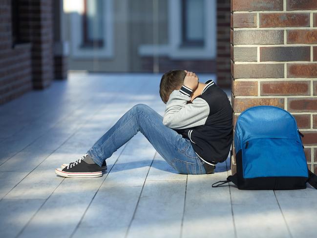 schoolboy crying in the hallway of the school, negative emotion