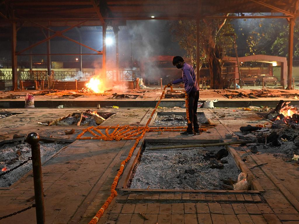 A crematorium staff member places garlands before a cremation this week. Picture: Sajjad Hussain/AFP