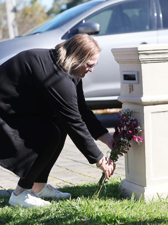 A neighbour lays flowers outside the Campbelltown home. Picture: NCA NewsWire / David Mariuz